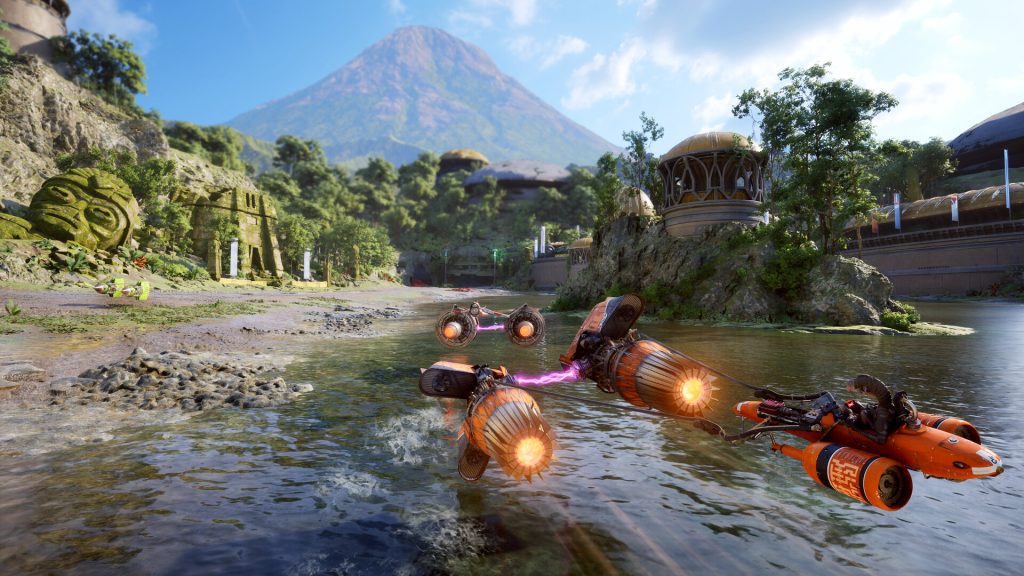 Podracers skimming across a jungle river below a volcano in Star Wars: Galactic Racer