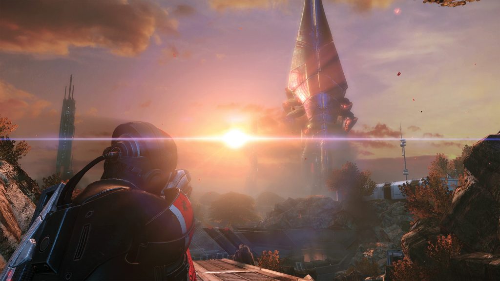 Commander Shepard watching the sun set over a battlefield in Mass Effect Legendary Edition