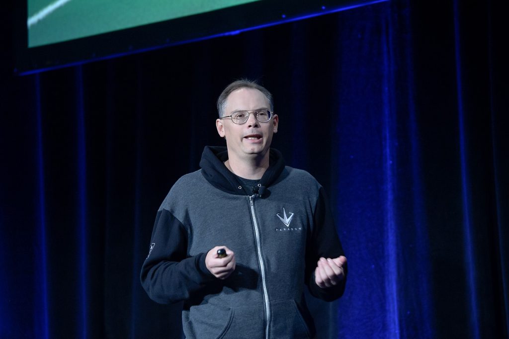 Tim Sweeney giving a talk at GDC 2016 in a grey Paragon hoodie